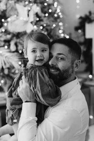 Ritratto in bianco e nero di un papà con la figlia in braccio