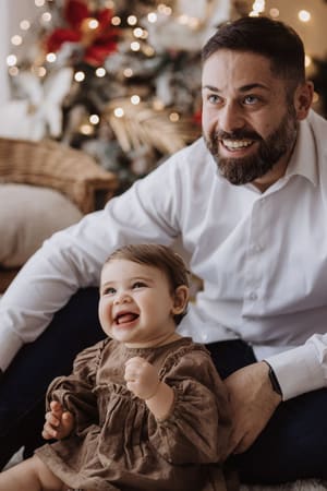 Papà e figlia che ridono insieme seduti a terra