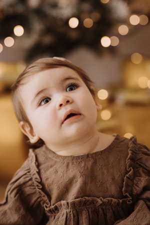 Primo piano di una bambina che guarda in alto verso le luci